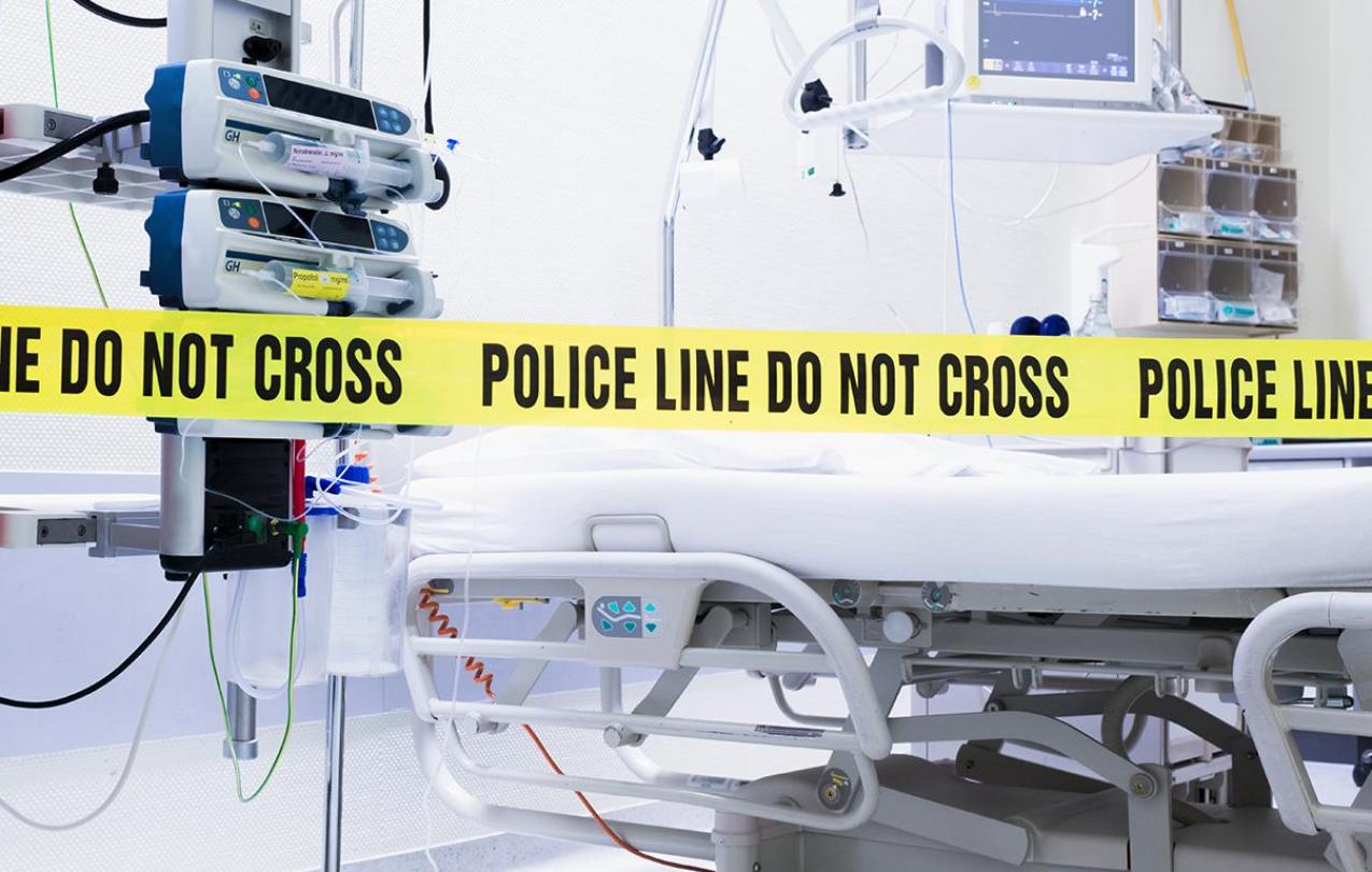 Police tape surrounding a hospital bed